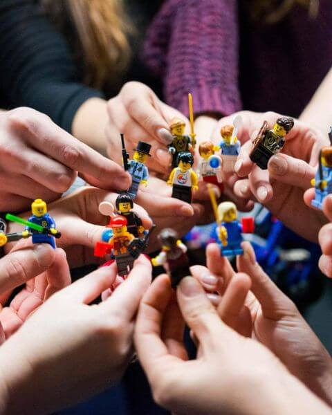 hands holding lego characters