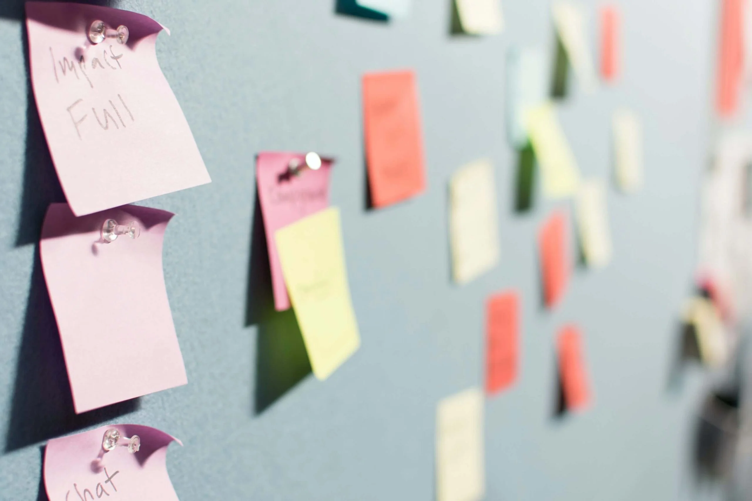 post-it notes pinned to a wall in a workplace